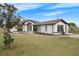 Beautifully landscaped single-Gathering home with a well-manicured lawn and a white facade at 15111 Peach Bloom Rd, Brooksville, FL 34614