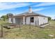 Rear exterior view featuring covered patio, chimney, garden bed and fenced backyard at 15111 Peach Bloom Rd, Brooksville, FL 34614