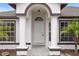 Inviting front entrance featuring white door, arched entryway, and decorative columns at 15111 Peach Bloom Rd, Brooksville, FL 34614