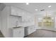 Bright kitchen boasts white cabinetry, stainless steel appliances, and a modern sink with views at 15111 Peach Bloom Rd, Brooksville, FL 34614