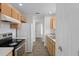 Bright kitchen featuring wood cabinets, white appliances, tile backsplash, and wood-look flooring at 15111 Peach Bloom Rd, Brooksville, FL 34614