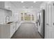 Modern kitchen with white cabinets, quartz countertops, stainless steel appliances, and hardwood flooring at 15111 Peach Bloom Rd, Brooksville, FL 34614