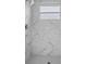 Shower boasting white marble-look tile surround, a window and modern fixtures at 15111 Peach Bloom Rd, Brooksville, FL 34614