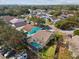 Aerial view of the back of a home showcasing the screened pool and proximity to the neighbors at 1758 Biarritz Cir, Tarpon Springs, FL 34689