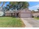 Pink one-story house with a two-car garage and landscaped yard at 2263 Whisper Walk Dr, Spring Hill, FL 34606