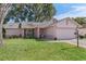 Pink one-story house with a two-car garage and well-maintained lawn at 2263 Whisper Walk Dr, Spring Hill, FL 34606