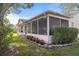 Home exterior showcasing a screened porch and well-manicured lawn at 2263 Whisper Walk Dr, Spring Hill, FL 34606