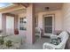 White wicker chairs sit on a covered porch with brick columns at 2263 Whisper Walk Dr, Spring Hill, FL 34606
