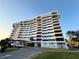 Stunning view of the white condominium building exterior against a clear, blue sky on a sunny day at 30 Turner St # 208, Clearwater, FL 33756
