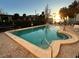Inviting community pool with lush landscaping and a serene waterfront view at sunset at 30 Turner St # 208, Clearwater, FL 33756