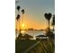 Beautiful water view with a gazebo on the waterfront, tall palm trees, and a vibrant sunset skyline at 30 Turner St # 208, Clearwater, FL 33756