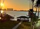 Scenic water view featuring a gazebo on the waterfront, palm trees, and a stunning sunset backdrop at 30 Turner St # 208, Clearwater, FL 33756