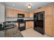 Modern kitchen featuring granite countertops, tile flooring, and stainless steel appliances at 3713 Modesto St, New Port Richey, FL 34655