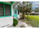 Side entrance of home near canal, featuring vibrant green trim at 5648 Riverview Dr, New Port Richey, FL 34652