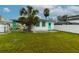 Expansive backyard with views of palm trees and carport at 5648 Riverview Dr, New Port Richey, FL 34652