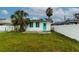 Backyard view featuring a small palm tree and vibrant green trim details at 5648 Riverview Dr, New Port Richey, FL 34652