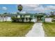 Single-story home with green trim, a carport, and a well-kept lawn at 5648 Riverview Dr, New Port Richey, FL 34652