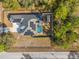 Aerial view of the home with solar panels and screened in pool surrounded by lush landscaping at 7482 Winter St, Brooksville, FL 34613