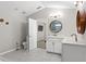 Comfortable bathroom with double sinks, white vanity and toilet, and round mirrors at 7482 Winter St, Brooksville, FL 34613