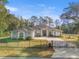 The front of a single-story home with a gated driveway and mature trees in the background at 7482 Winter St, Brooksville, FL 34613