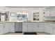 Bright kitchen featuring stainless steel dishwasher, white cabinets, granite countertops, and an exterior window with a view at 7482 Winter St, Brooksville, FL 34613
