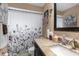 Bathroom with a shower/tub combo, granite countertop, and floral shower curtain at 7489 Gates Cir, Spring Hill, FL 34606
