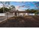 Single-story house with a brown roof, white fence, and a well-maintained lawn at 7489 Gates Cir, Spring Hill, FL 34606