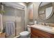 Bathroom features a glass-enclosed shower, wood vanity, and a large round mirror at 8194 Sturbridge Ct # A, Weeki Wachee, FL 34613