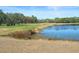 Picturesque pond alongside a green golf course with colorful trees under a blue sky at 8194 Sturbridge Ct # A, Weeki Wachee, FL 34613