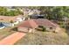 An aerial view of a single Gathering home with mature landscaping, driveway, and brick exterior at 8464 Dirlenton Way, Weeki Wachee, FL 34613