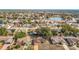 Neighborhood aerial view showcasing a home with a brick exterior, mature trees, and a nearby lake at 8464 Dirlenton Way, Weeki Wachee, FL 34613