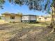 A home's grassy backyard with a back porch on a sunny day at 8464 Dirlenton Way, Weeki Wachee, FL 34613