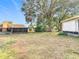 A home's spacious backyard and screen porch under a sunny sky at 8464 Dirlenton Way, Weeki Wachee, FL 34613