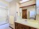 Bathroom featuring a walk-in shower, large mirror, and wooden cabinets at 8464 Dirlenton Way, Weeki Wachee, FL 34613