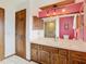 Bathroom featuring wooden cabinets, a tiled counter, and a large mirror at 8464 Dirlenton Way, Weeki Wachee, FL 34613