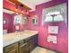 Bathroom featuring bold pink walls, tiled counters, and decorative accents at 8464 Dirlenton Way, Weeki Wachee, FL 34613