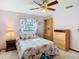 Cozy bedroom with ceiling fan, floral bedding, and wooden furniture at 8464 Dirlenton Way, Weeki Wachee, FL 34613