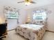 Light-filled bedroom featuring floral bedding, curtains, and a ceiling fan at 8464 Dirlenton Way, Weeki Wachee, FL 34613