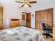 Bedroom with wooden furniture, including a wardrobe, and a ceiling fan at 8464 Dirlenton Way, Weeki Wachee, FL 34613