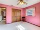Bedroom featuring a wardrobe, a ceiling fan and pink walls at 8464 Dirlenton Way, Weeki Wachee, FL 34613