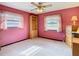 Bedroom with ceiling fan, natural lighting and pink walls at 8464 Dirlenton Way, Weeki Wachee, FL 34613