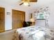 Bedroom featuring light-colored floral bedding, ceiling fan and a wooden wardrobe at 8464 Dirlenton Way, Weeki Wachee, FL 34613