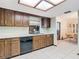 Kitchen featuring wooden cabinets, white countertops, black appliances, and tile flooring at 8464 Dirlenton Way, Weeki Wachee, FL 34613