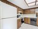 A kitchen with wood cabinets, a white refrigerator and oven, and black dishwasher at 8464 Dirlenton Way, Weeki Wachee, FL 34613