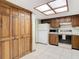 A kitchen with wooden cabinets, a white refrigerator and oven, and a skylight at 8464 Dirlenton Way, Weeki Wachee, FL 34613
