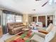 Spacious living room with neutral tones, plush seating, large window, and stylish ceiling fan at 8464 Dirlenton Way, Weeki Wachee, FL 34613