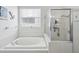 Clean bathroom featuring a soaking tub with a glass-enclosed shower and window at 8709 Maple Pond Ct, Trinity, FL 34655