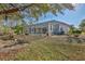 View of the screened-in lanai, lush landscaping, and spacious backyard at 9091 Alexandria Dr, Weeki Wachee, FL 34613