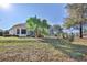 Exterior view of the home showcasing the screened lanai and mature landscaping at 9091 Alexandria Dr, Weeki Wachee, FL 34613