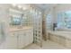 Spacious bathroom with glass block shower, tub with shuttered windows, and tiled floors at 9091 Alexandria Dr, Weeki Wachee, FL 34613